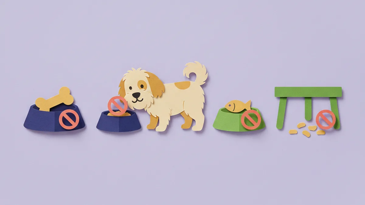 Paper-craft scene of dogs fed at separate stations behind a gate, with bowls picked up, preventing cross-contamination during a food trial